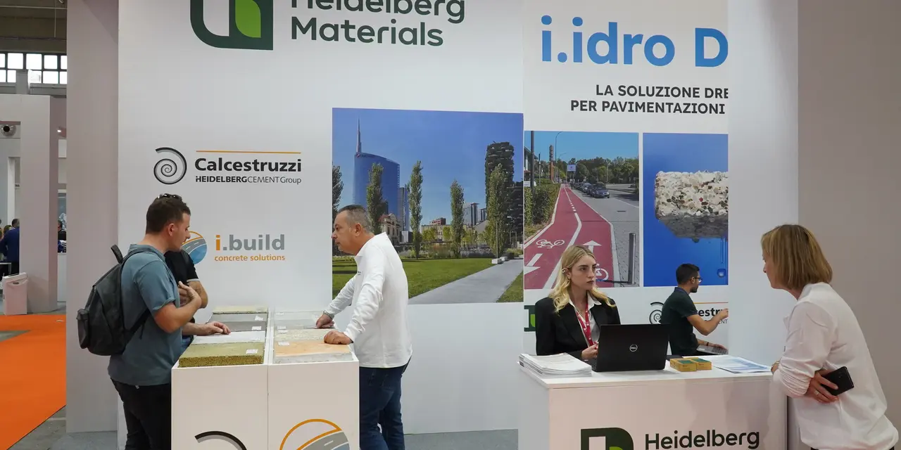 Stand informativo di Heidelberg Materials con personale che interagisce con i visitatori.