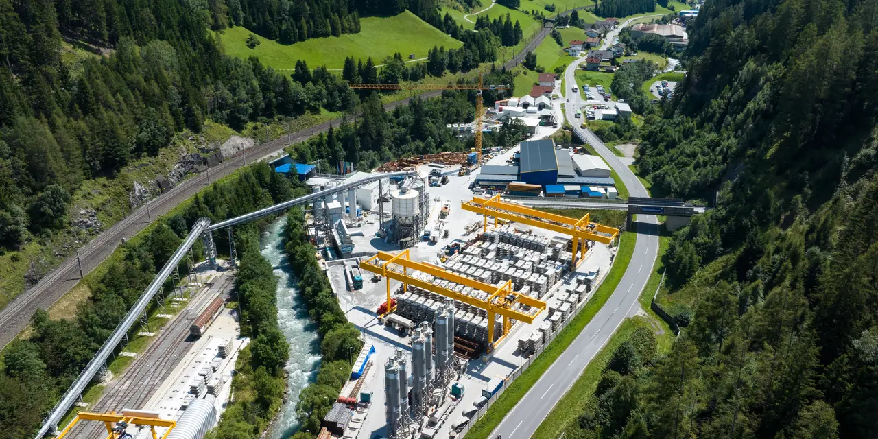 Vista aerea di un impianto industriale circondato da un paesaggio montano verde.