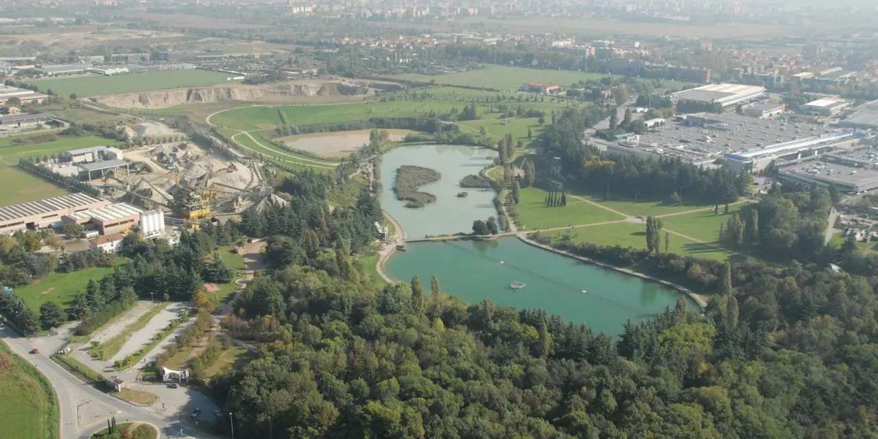 Vista aerea di un sito industriale con aree verdi integrate e un lago artificiale.
