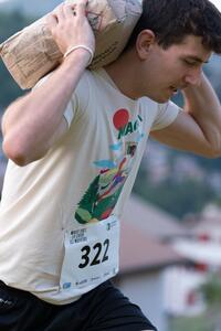Un uomo trasporta un sacco di materiali da costruzione sulle spalle durante un evento.