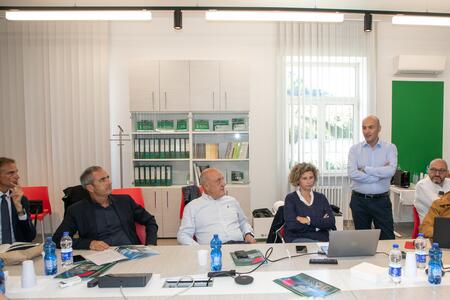 Un gruppo di persone riunite attorno a un tavolo in una sala conferenze aziendale.