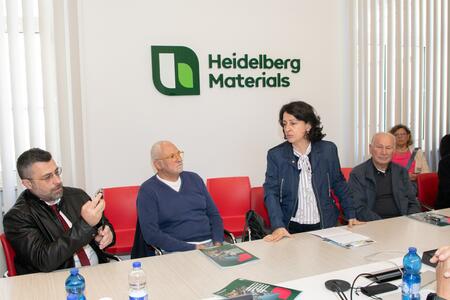 Persone in una sala riunioni con materiale promozionale Heidelberg Materials sul tavolo.